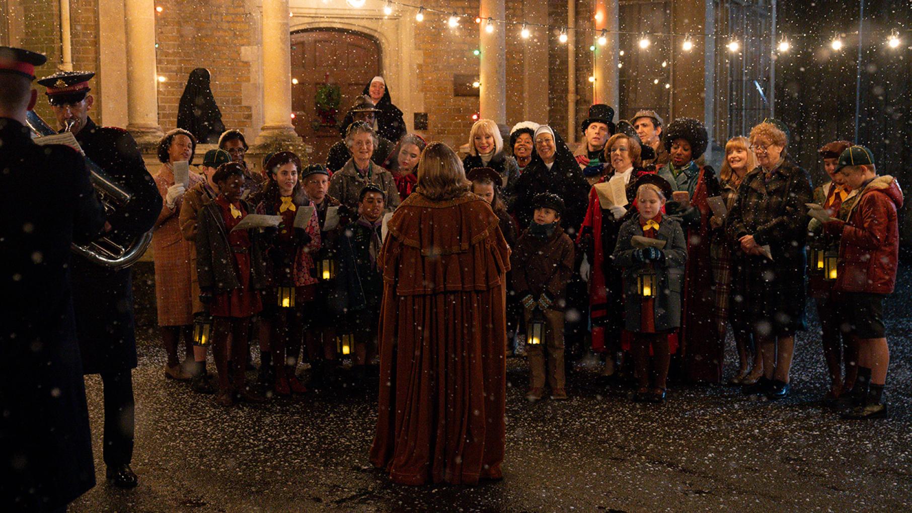 A crowd of carolers outside